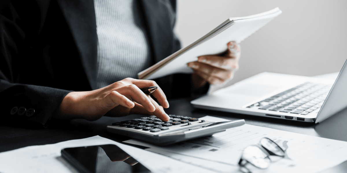 Accounting professional performing calculations while reviewing financial documents - representing career opportunities available through CPA prerequisite courses and accounting certification without degree requirements.